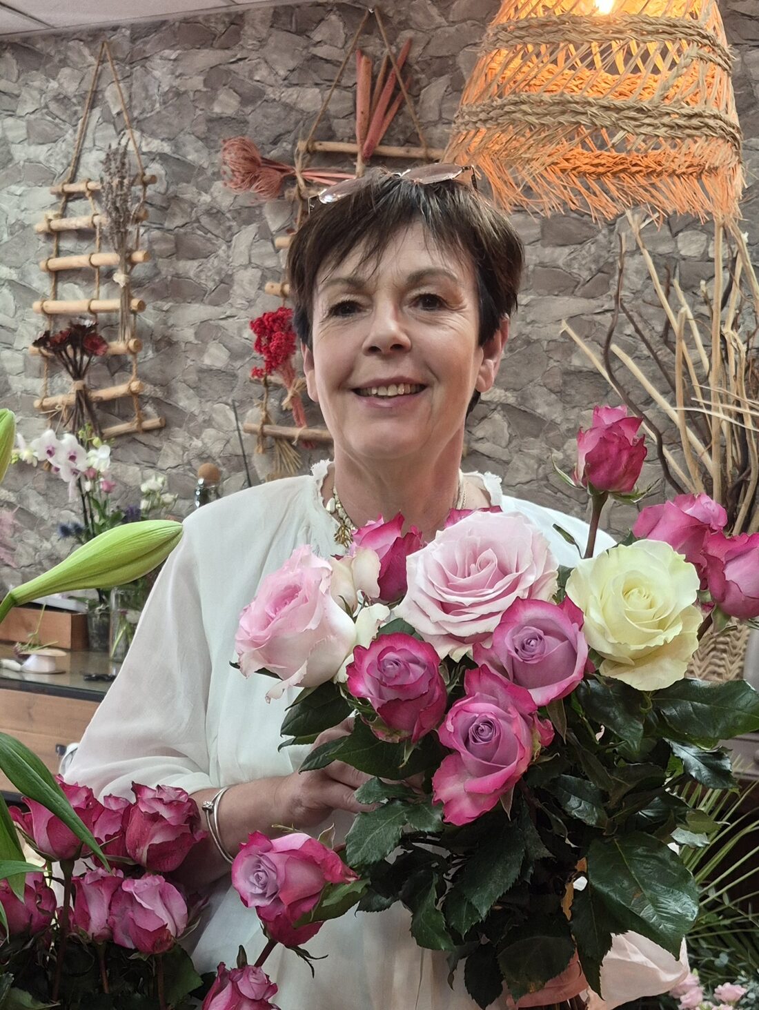 Une fleuriste de Cap Vert avec un bouquet de roses, dans la boutique à Quint-Fonsegrives